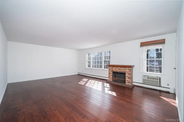 an empty room with fireplace and wooden floor