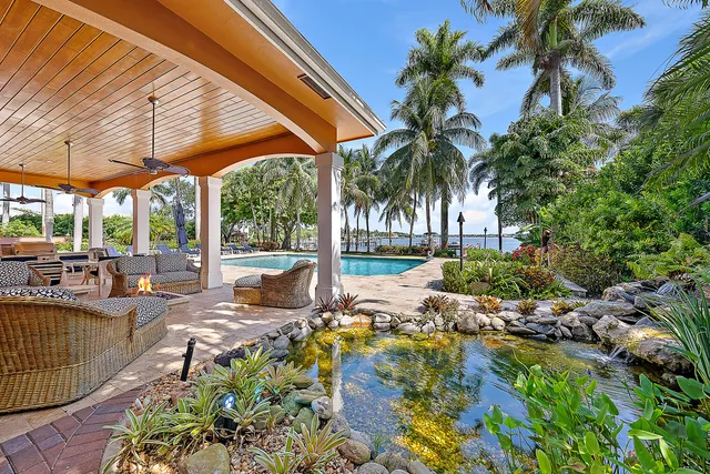 a view of backyard with swimming pool outdoor seating and green space