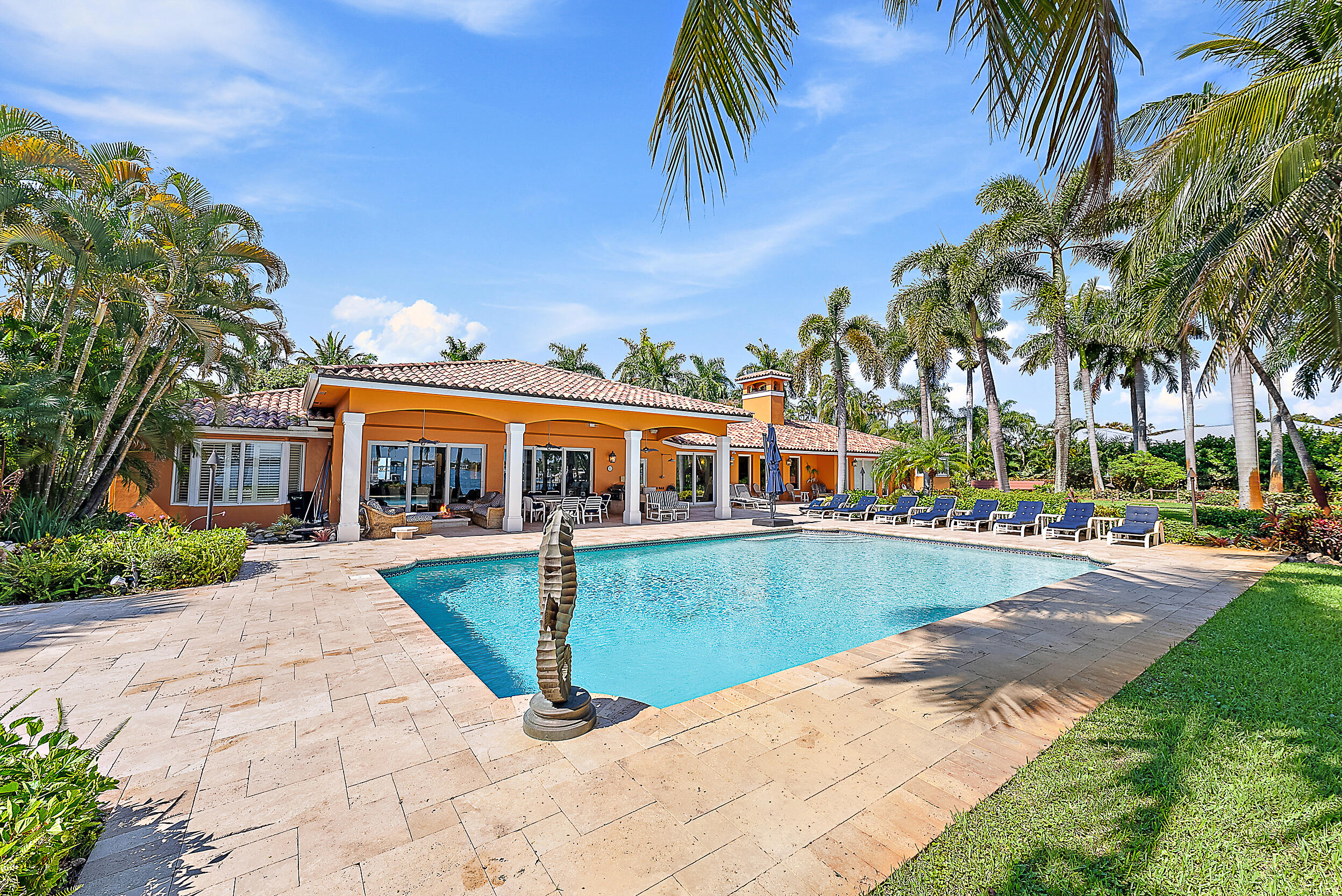 5900 Pennock Point Road Jupiter, FL 33458 - Photo 9 of 21 a view of a swimming pool with lawn chairs under an umbrella