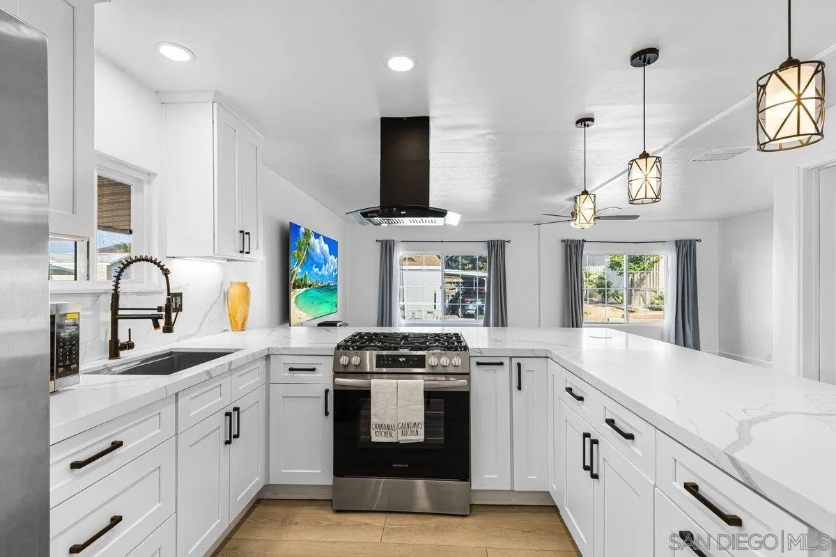 a kitchen with stainless steel appliances granite countertop a stove a sink and a microwave