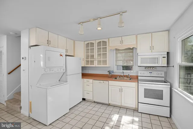a kitchen with white cabinets and white appliances