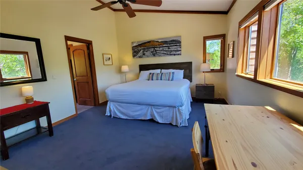 a bedroom with a bed and a dresser next to a window