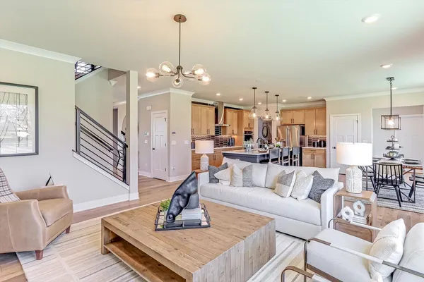 a living room with furniture kitchen view and a chandelier