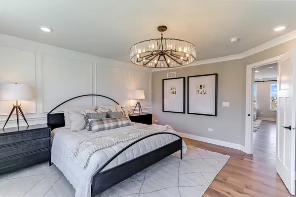 a bedroom with a large bed and a chandelier
