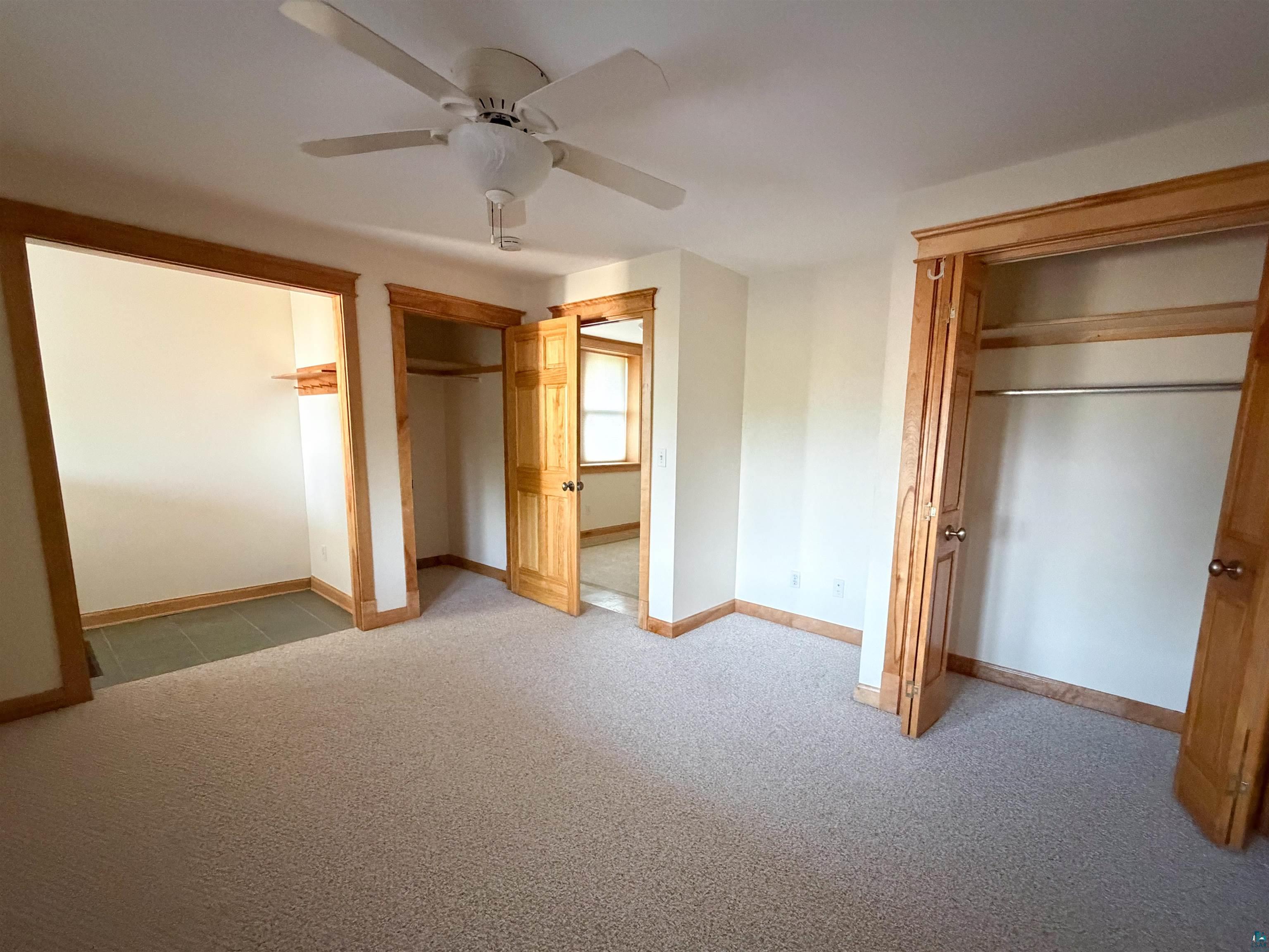 13 West 8th Street Duluth, MN 55806 - Photo 41 of 57 Carpeted room featuring a ceiling fan, light wood-finish trim and doors, and two closet spaces