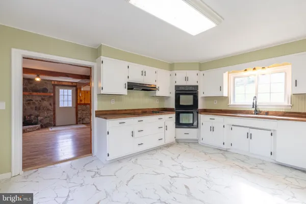 a kitchen with granite countertop a stove a sink and a refrigerator