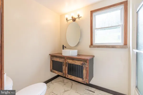 a bathroom with a toilet a sink and mirror