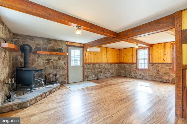 a view of an empty room with a fireplace and windows