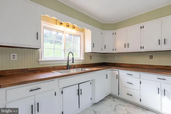 a kitchen with white cabinets and a sink