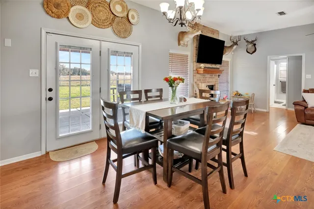 a view of a dining room with furniture a chandelier and wooden floor