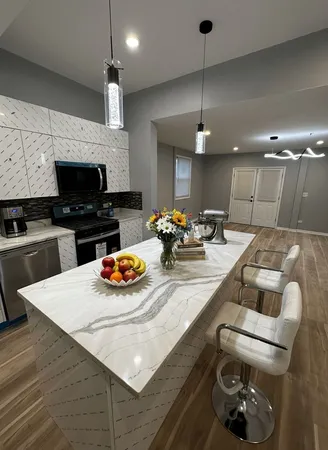 a view of a kitchen with kitchen island stainless steel appliances refrigerator stove microwave and cabinets