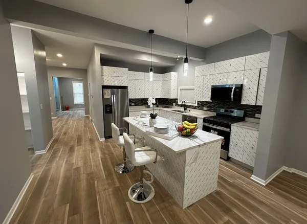 a kitchen with a sink stove and wooden floor