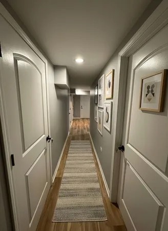 a view of a hallway with wooden floor and a cabinet