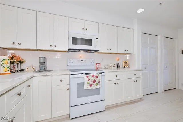 a kitchen with white cabinets and white appliances
