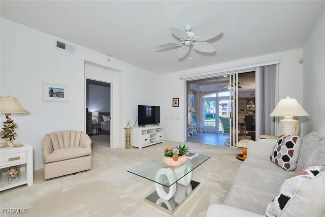 a living room with furniture and a table and a chandelier