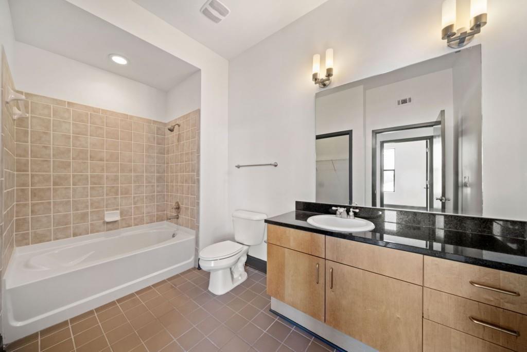 5300 Peachtree Road, Unit 3507 Atlanta, GA 30341 - Photo 25 of 32 a bathroom with a granite countertop sink a toilet a mirror and bathtub