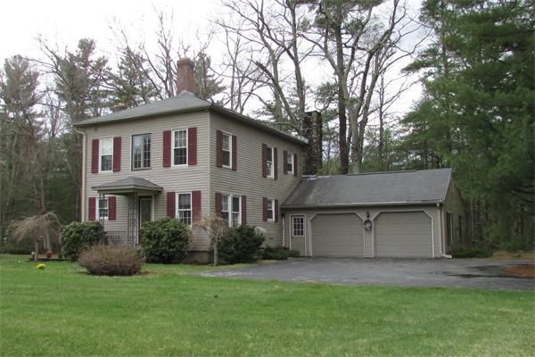 a front view of a house with a garden and plants