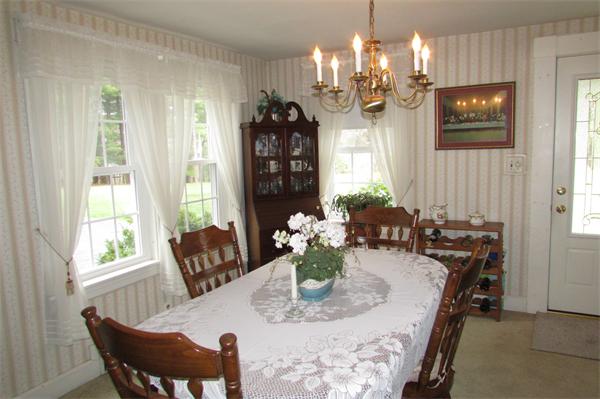 60 Farquhar Road Sturbridge, MA 01566 - Photo 4 of 30 a view of a dining room with furniture a chandelier and large windows