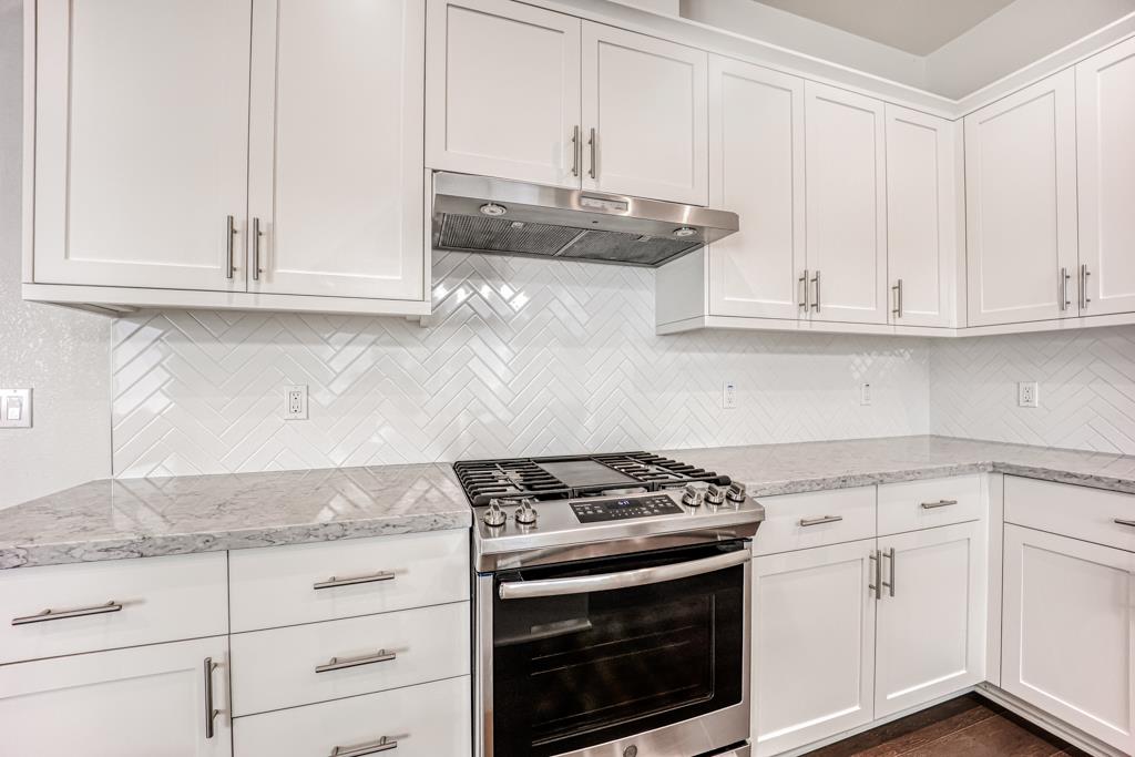 183 Nexus Loop San Jose, CA 95110 - Photo 19 of 33 a kitchen with granite countertop white cabinets and a stove