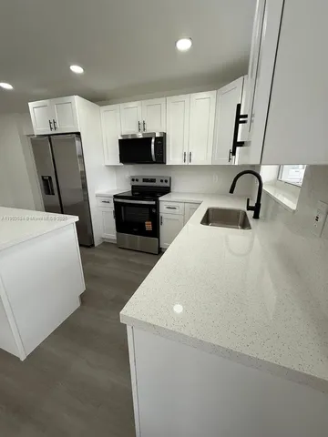 a kitchen with stainless steel appliances a refrigerator a sink a stove top oven a sink and dishwasher