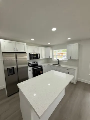 a kitchen with stainless steel appliances a refrigerator sink and microwave