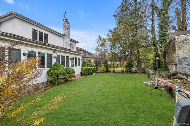 a front view of a house with garden and trees
