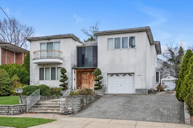 a front view of a house with garage and parking