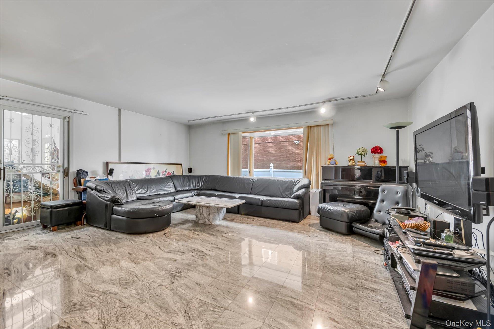252-71 Brattle Avenue Queens, NY 11362 - Photo 2 of 20 a living room with furniture and a flat screen tv