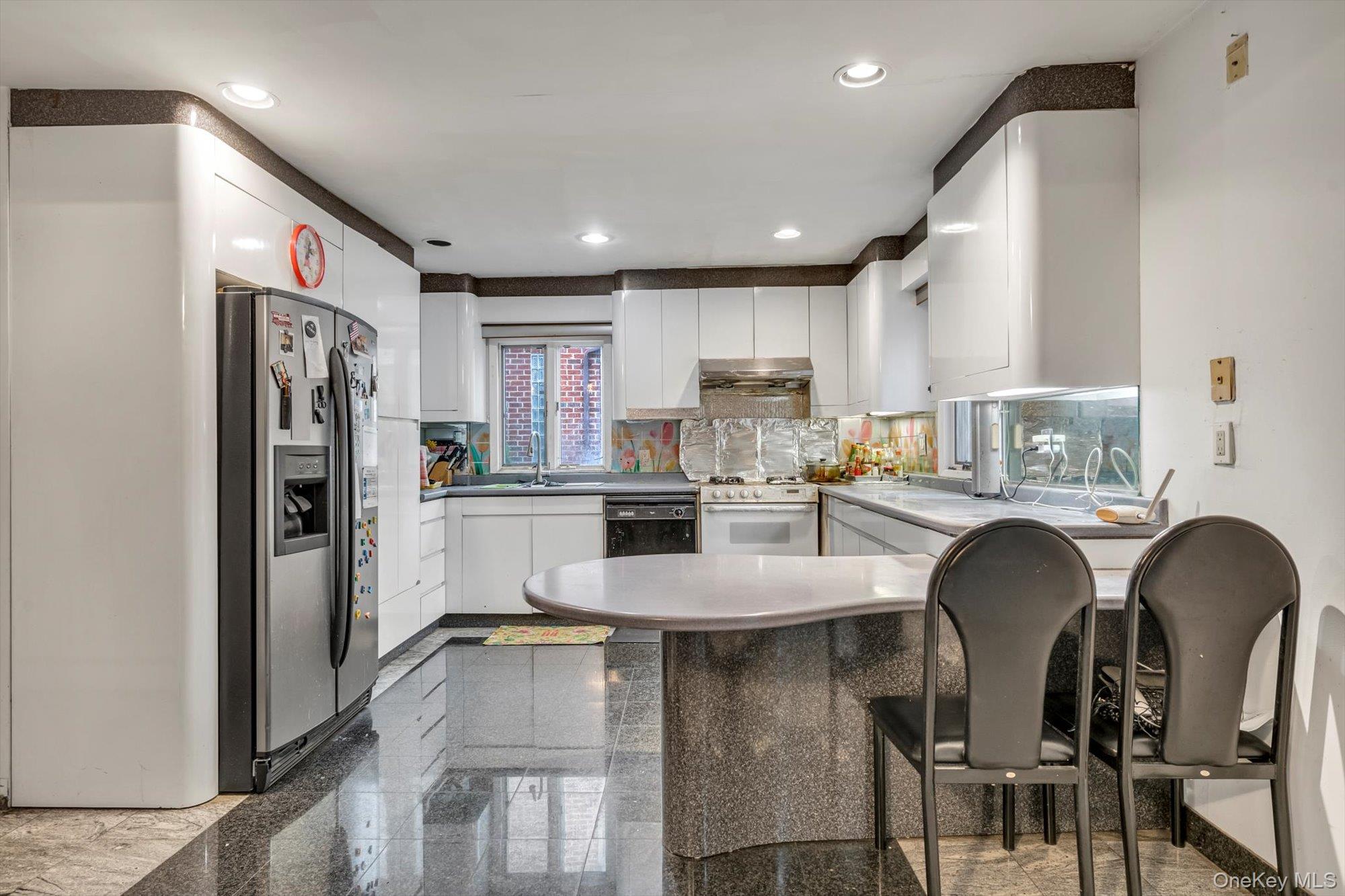 252-71 Brattle Avenue Queens, NY 11362 - Photo 4 of 20 a kitchen with stainless steel appliances granite countertop a refrigerator a sink a stove a dining table and chairs
