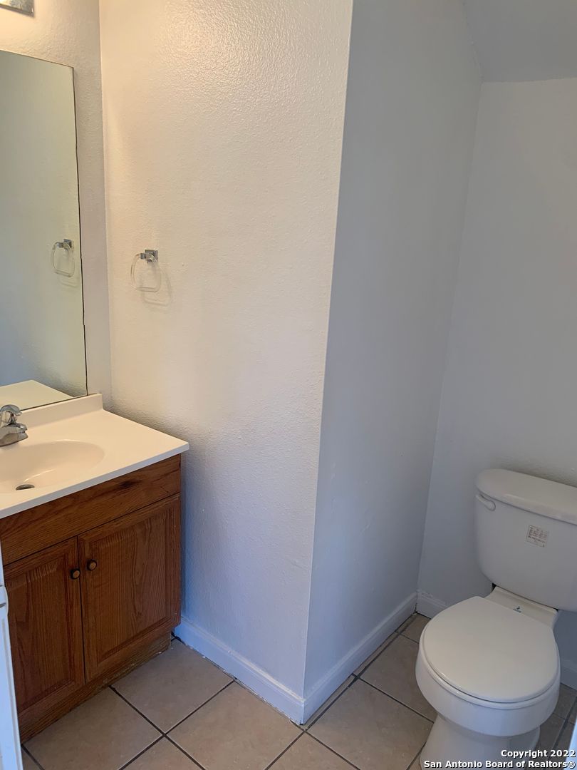 6911 Hallie Ridge San Antonio, TX 78227 - Photo 14 of 22 a bathroom with a granite countertop toilet and a sink
