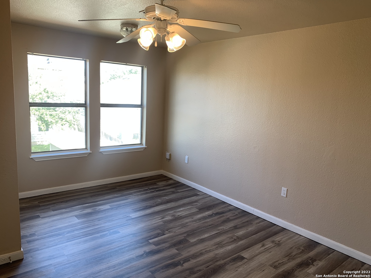 6911 Hallie Ridge San Antonio, TX 78227 - Photo 9 of 22 a view of an empty room with wooden floor and a window