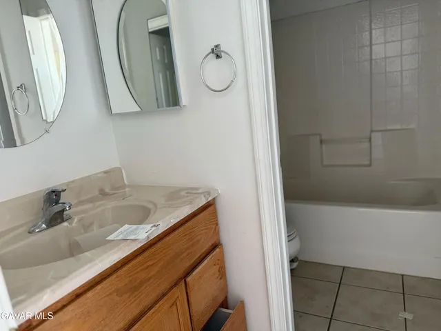 a bathroom with a granite countertop sink mirror and vanity