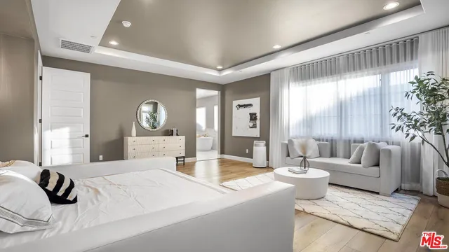 a en suite bathroom with a granite countertop tub sink and mirror