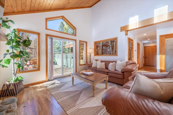 a view of balcony with wooden floor outdoor seating and yard in the back