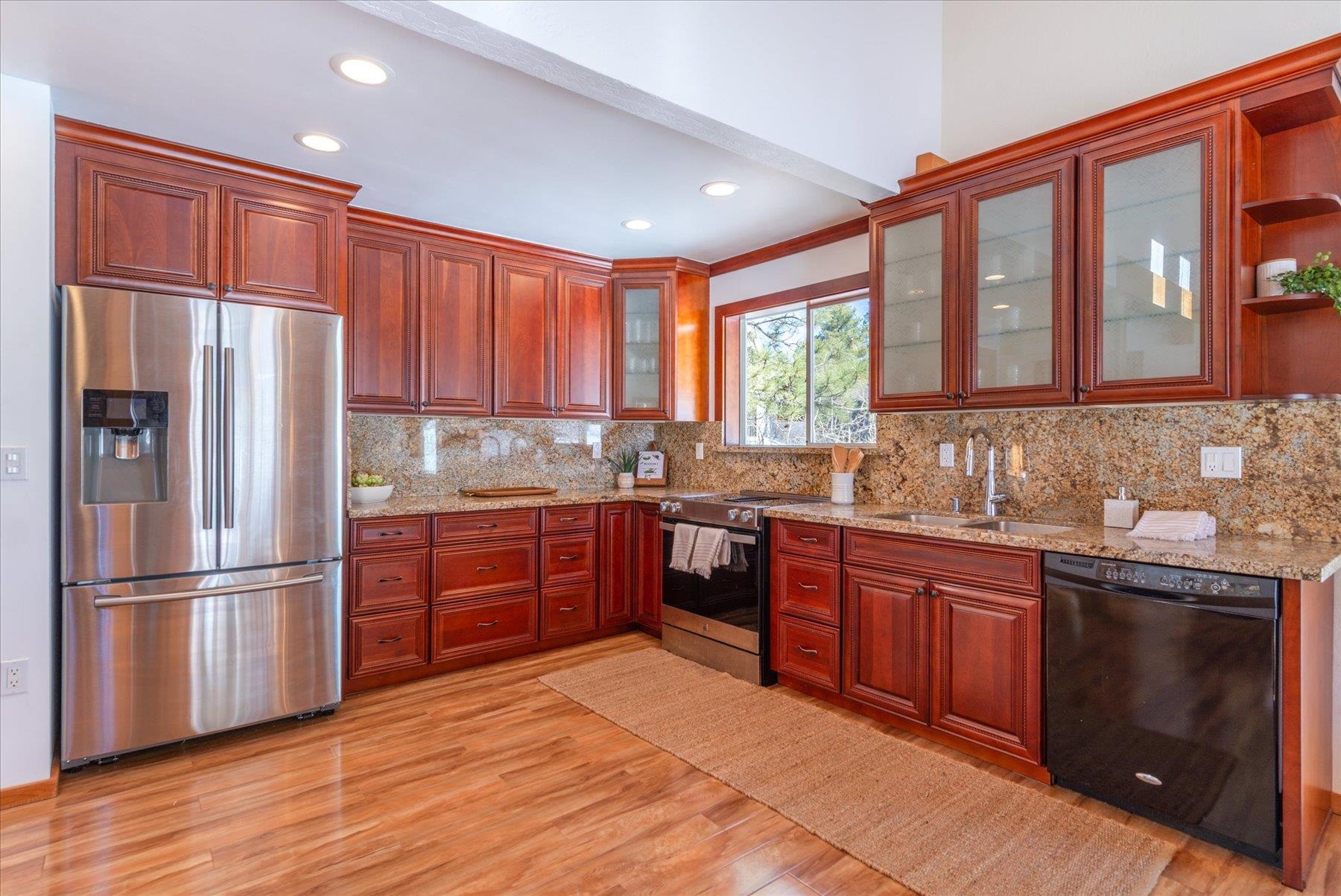 265 Basque Drive Truckee, CA 96161 - Photo 9 of 25 a kitchen with stainless steel appliances granite countertop a refrigerator a sink dishwasher a stove with wooden cabinets and floor