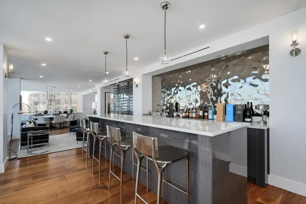 a kitchen with stainless steel appliances granite countertop table chairs stove and wooden floor