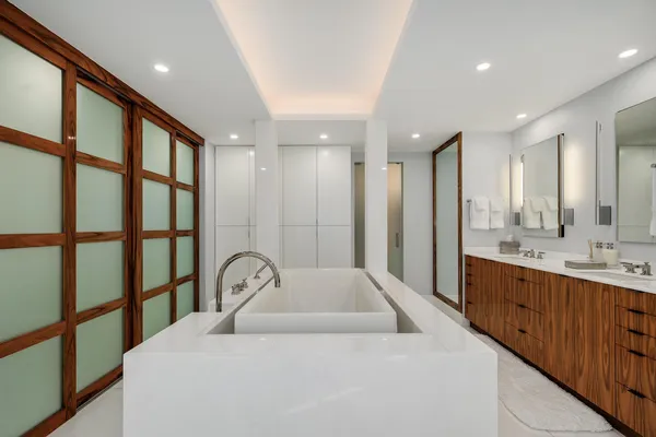 a large white kitchen with a large window and sink