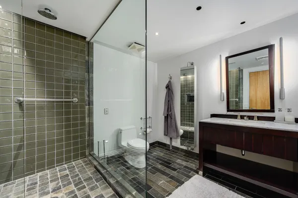 a bathroom with a double vanity sink a toilet and a mirror