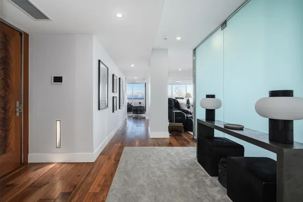 a view of a hallway with furniture and a window