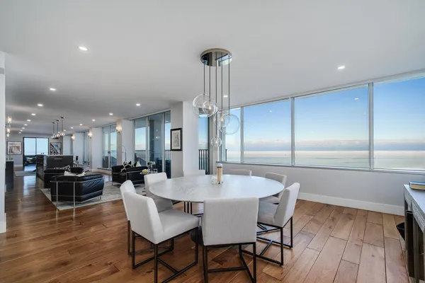 a dining room with furniture a chandelier and wooden floor
