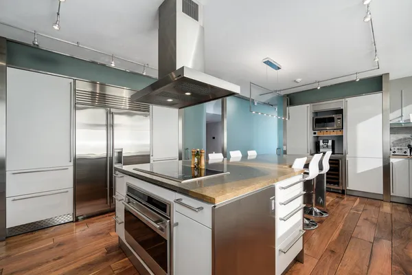 a kitchen with stainless steel appliances granite countertop a sink and a refrigerator