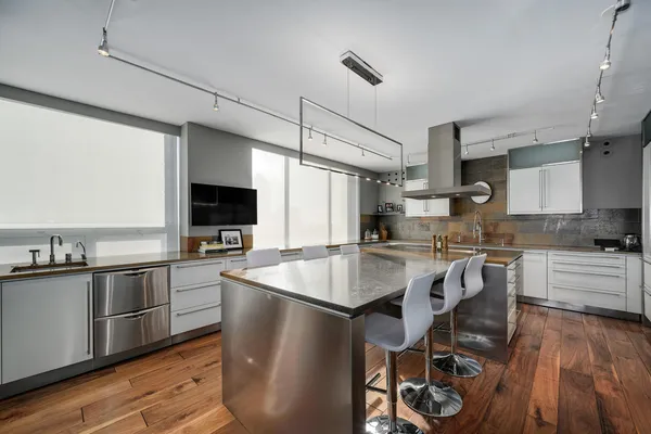 a kitchen with stainless steel appliances granite countertop a sink a stove and a refrigerator