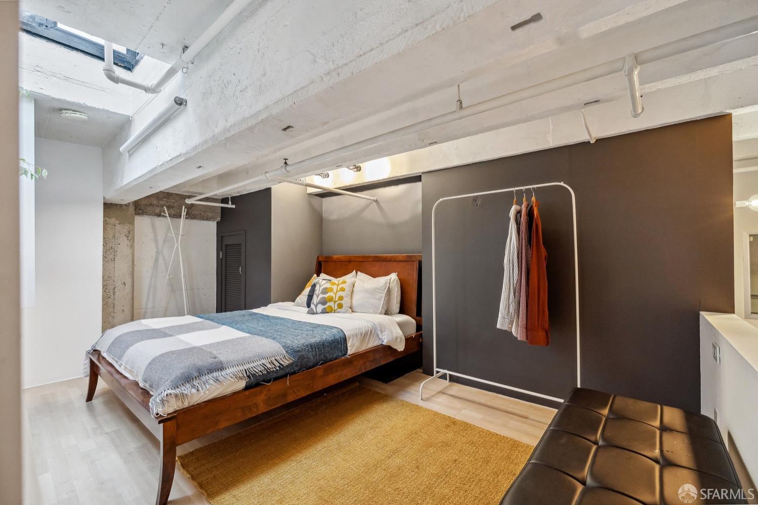 247 4th Street, Unit 406 Oakland, CA 94607 - Photo 11 of 46 a bedroom with a bed and a walk in closet