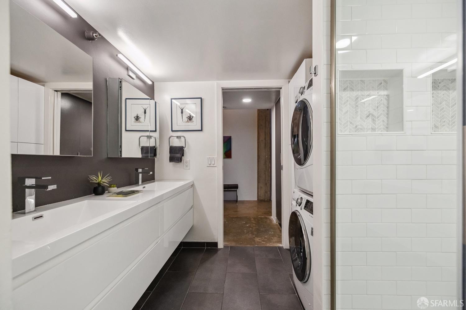 247 4th Street, Unit 406 Oakland, CA 94607 - Photo 17 of 46 a en suite bathroom with a sink a mirror and shower