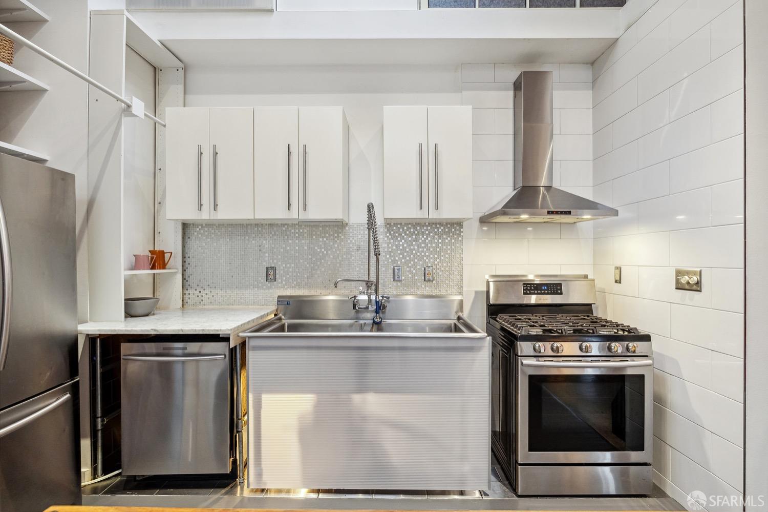 247 4th Street, Unit 406 Oakland, CA 94607 - Photo 23 of 46 a kitchen with stainless steel appliances a stove a sink and a refrigerator