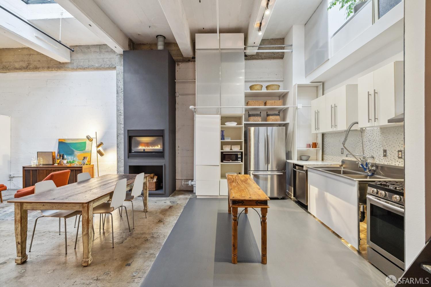 247 4th Street, Unit 406 Oakland, CA 94607 - Photo 24 of 46 a large kitchen with stainless steel appliances kitchen island granite countertop a table chairs in it