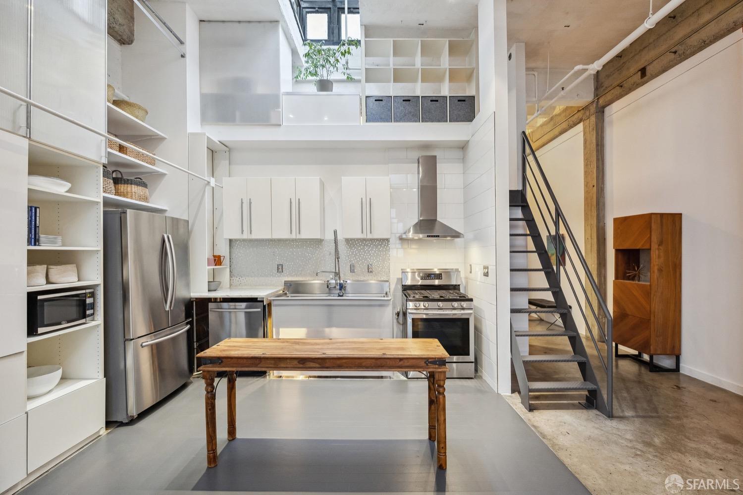 247 4th Street, Unit 406 Oakland, CA 94607 - Photo 25 of 46 a kitchen with stainless steel appliances granite countertop a refrigerator a stove and white cabinets with wooden floor