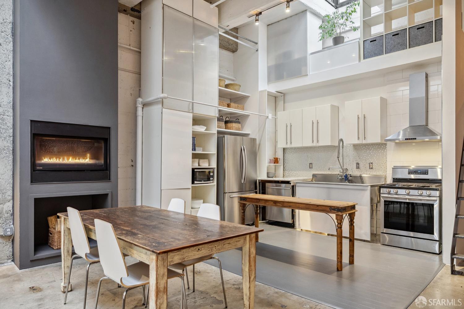 247 4th Street, Unit 406 Oakland, CA 94607 - Photo 26 of 46 a kitchen with stainless steel appliances kitchen island granite countertop a table chairs microwave and cabinets
