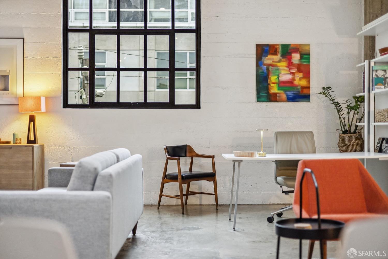 247 4th Street, Unit 406 Oakland, CA 94607 - Photo 35 of 46 a living room with furniture a rug and a wall painting