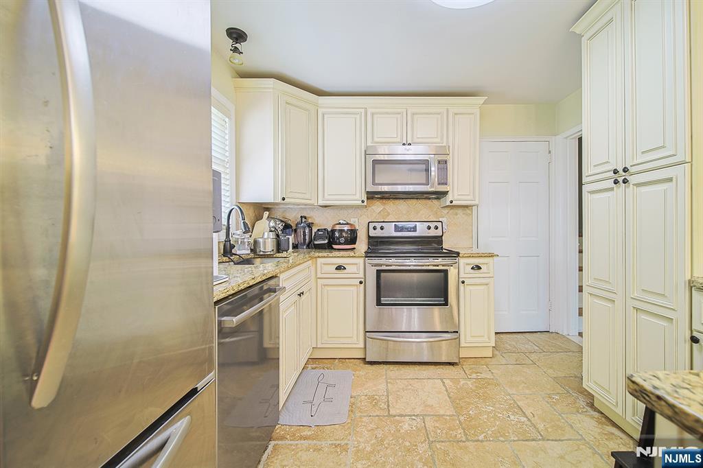 181 Crescent Street Closter, NJ 07624 - Photo 14 of 25 a kitchen with stainless steel appliances a stove a sink and a refrigerator